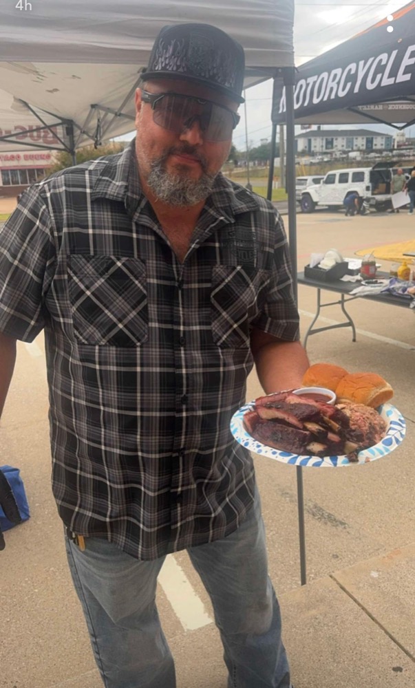 The pitmaster holding a fresh brisket